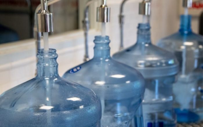 filling up big plastic bottles with purified water